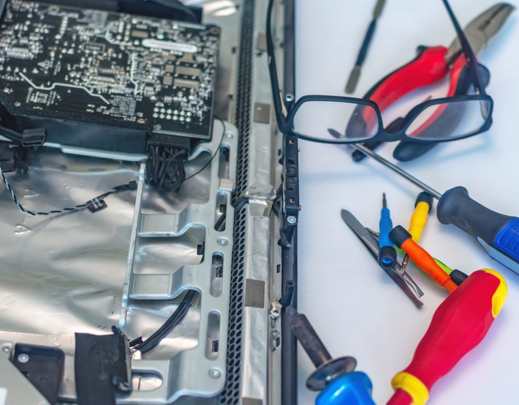 a man repairs a computer, solders a board, repairs electronics and modern technologies