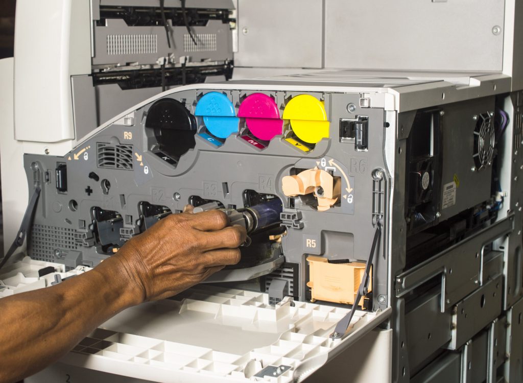 technician hand insert color copier drum in overhaul process on  isolate background